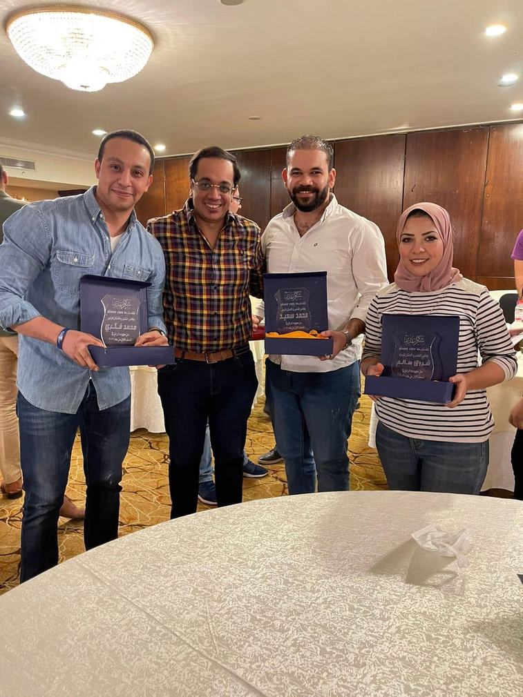 Colleagues receiving recognition awards from Planet Cure